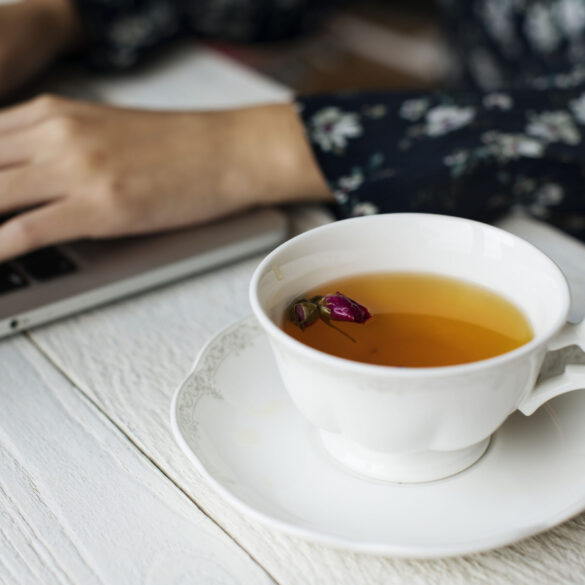 Woman working and a hot cup of floral tea